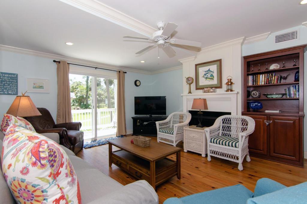 a living room with a couch and a tv at Driftwood Villa - 280 in Edisto Beach