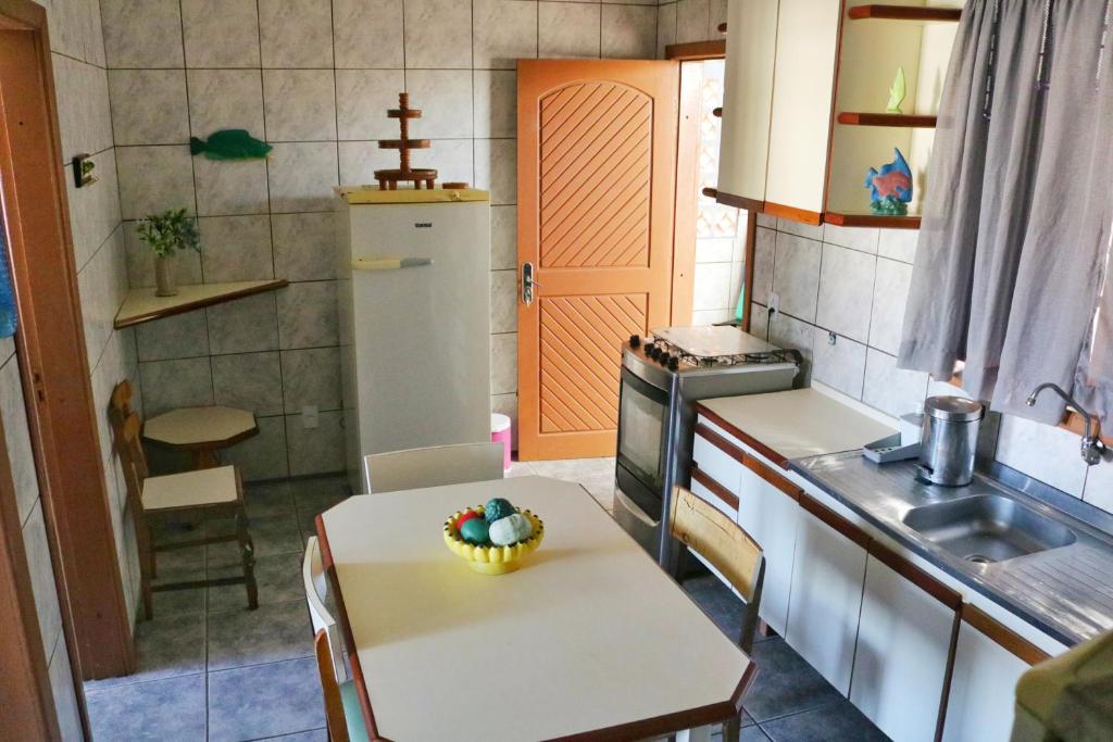una cocina con una mesa con un bol de fruta. en Apartamento Beira Mar en Pontal do Paraná