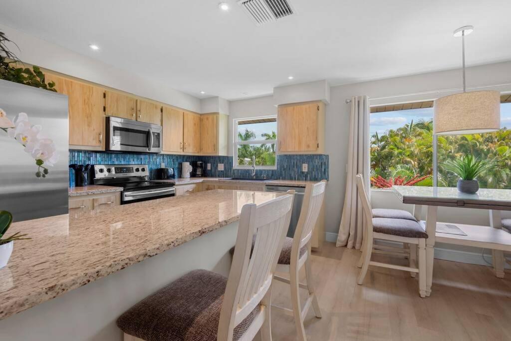 a kitchen with wooden cabinets and a table with chairs at The Tequila Sunrise at Lazy Way in Fort Myers Beach