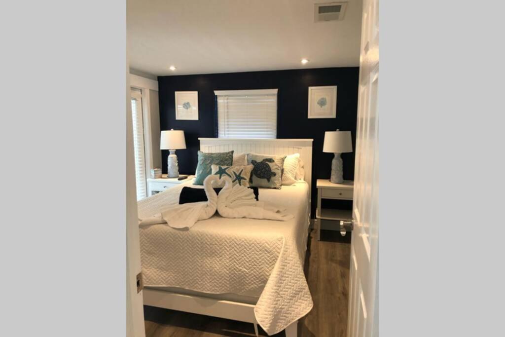um quarto com uma cama branca e uma parede preta em The Bahama Breeze at the Anchorage em Fort Myers Beach