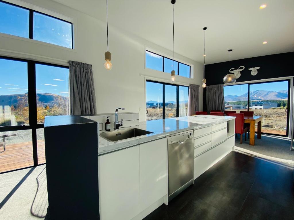 a kitchen with a sink and some windows at Flat White in Lake Tekapo