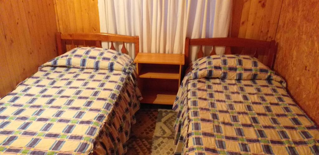 two beds sitting next to each other in a room at Hospedaje Picoyo in Pucón