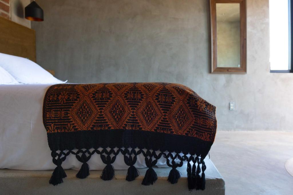 a bed with a brown and black blanket on it at Casa Michaus Valle de Guadalupe in Valle de Guadalupe