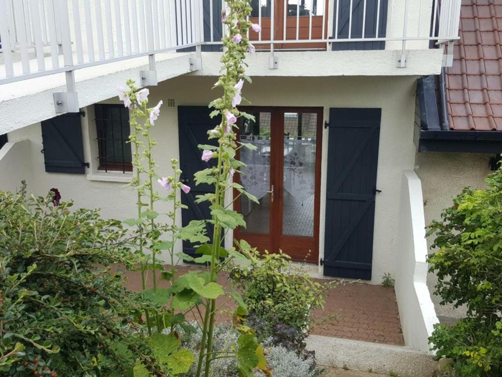 a house with a red door and a balcony at Studio Audinghen, 1 pièce, 2 personnes - FR-1-376-68 in Audinghen