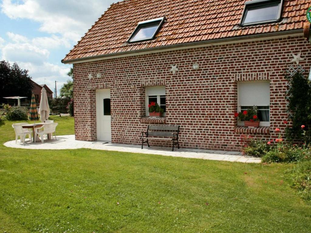 een stenen huis met een bank en een tafel bij Gîte Croisilles, 5 pièces, 7 personnes - FR-1-376-63 in Croisilles