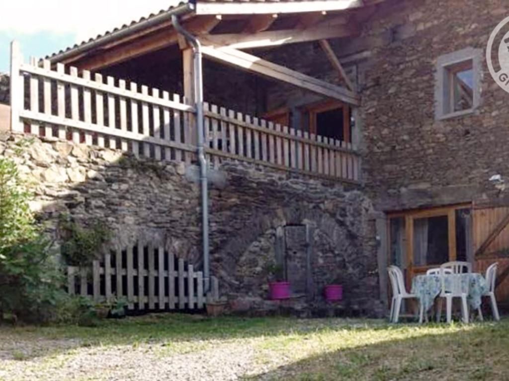 uma casa de pedra com uma mesa e cadeiras no quintal em Gîte La Terrasse-sur-Dorlay, 6 pièces, 13 personnes - FR-1-496-72 em La Terrasse-sur-Dorlay
