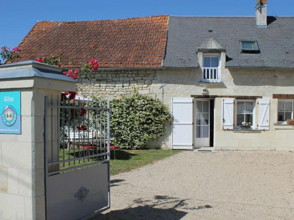 ein Haus mit einem Tor davor in der Unterkunft Gîte Savigny-en-Véron, 3 pièces, 4 personnes - FR-1-381-209 in Savigny-en-véron