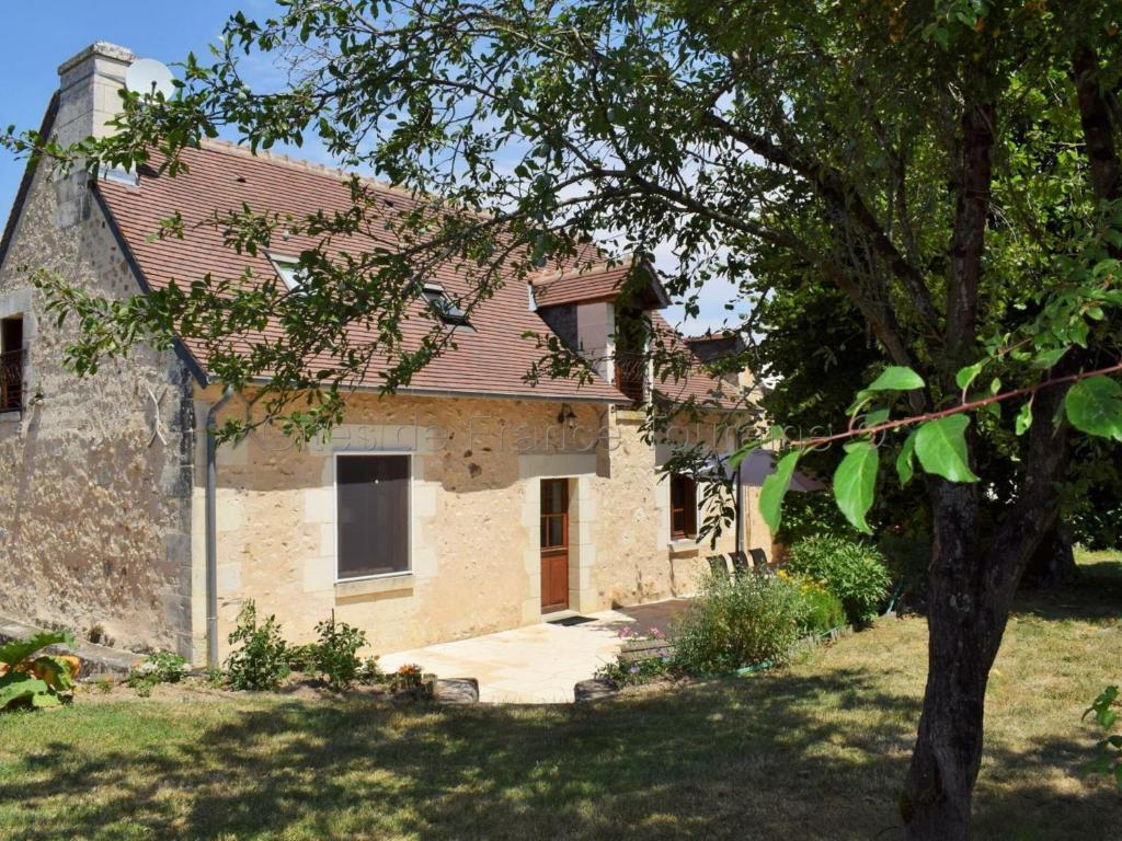 una casa de ladrillo con un árbol delante de ella en Gîte Paulmy, 4 pièces, 7 personnes - FR-1-381-321, en Paulmy