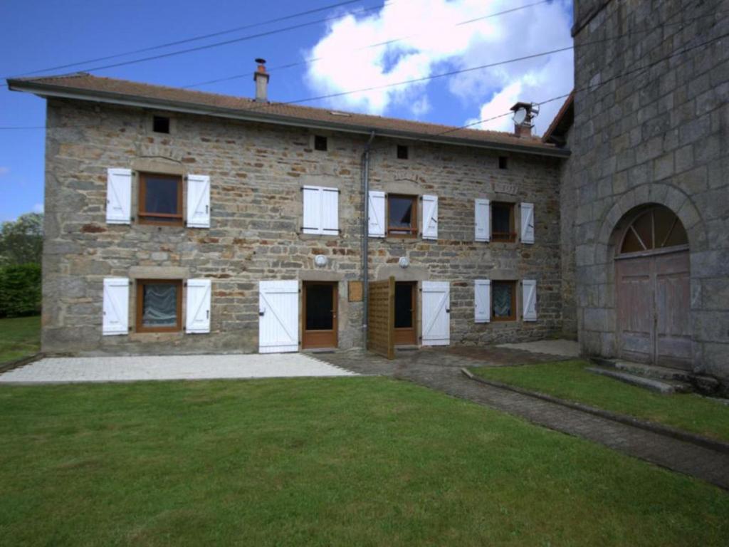 a large stone house with a grass yard in front of it at Gîte La Chambonie, 3 pièces, 4 personnes - FR-1-496-198 in La Chambonie