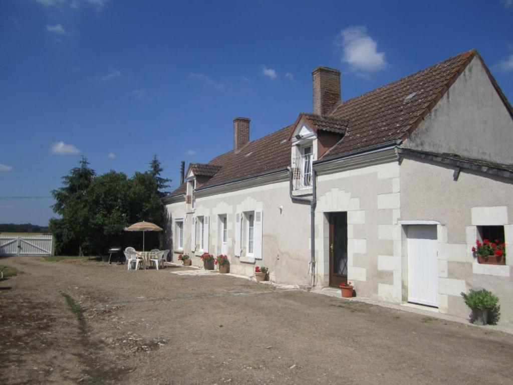 a white building with a table and an umbrella at Gîte Chaumont-sur-Loire, 4 pièces, 6 personnes - FR-1-491-240 in Chaumont-sur-Loire