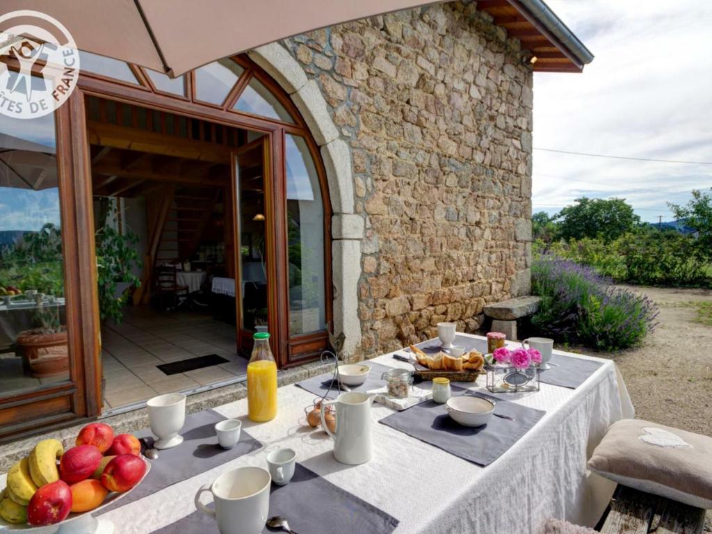 uma mesa com fruta na frente de um edifício em Gîte Les Salles, 4 pièces, 6 personnes - FR-1-496-61 em Les Salles