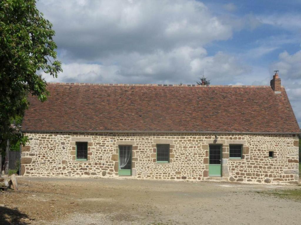 un edificio de piedra con techo marrón en Gîte La Baroche-sous-Lucé, 3 pièces, 5 personnes - FR-1-497-7, en La Baroche-sous-Lucé