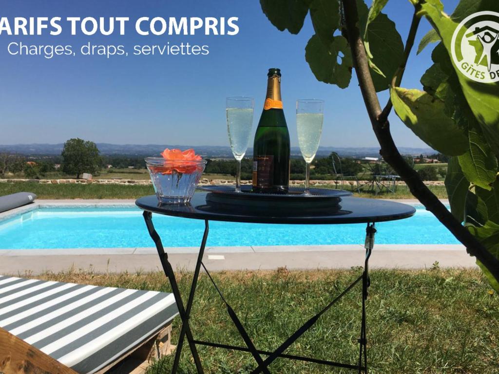 uma mesa com uma garrafa de champanhe e dois copos em Gîte Saint-André-d'Apchon, 2 pièces, 2 personnes - FR-1-496-142 em Saint-André-dʼApchon