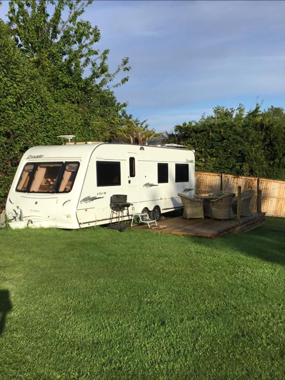 a white rv parked in a yard at Self Contained Holiday Home Caravan in Corsham