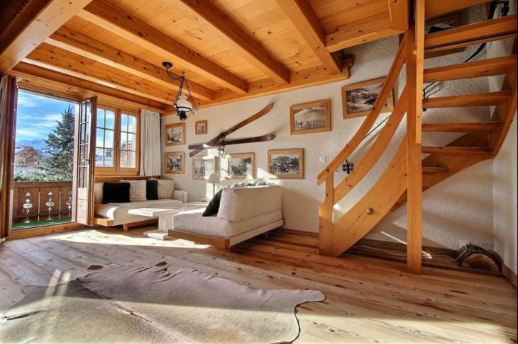 ein Wohnzimmer mit einer Treppe in einem Haus in der Unterkunft Chalet Soldanella 10 guests Gstaad in Gstaad