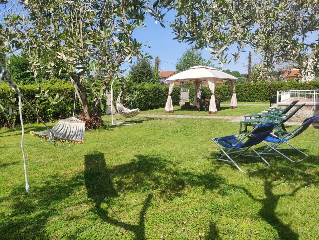 einen Garten mit zwei Gartenstühlen und einem Pavillon in der Unterkunft La Mimosa Chic in Pietrasanta