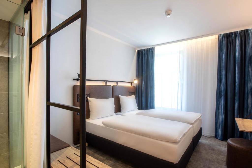 Un pat sau paturi într-o cameră la H2 Hotel Budapest