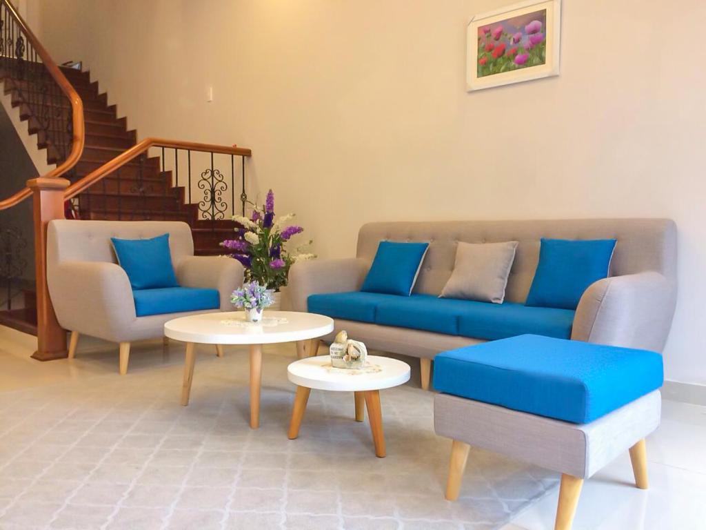 a living room with a couch and chairs and a table at Jolie House in Da Lat