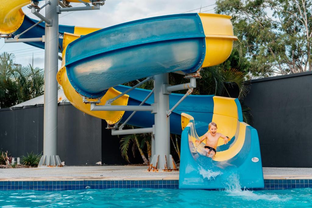 Un niño montando un tobogán acuático en un parque acuático en Nobby Beach Holiday Village, en Gold Coast