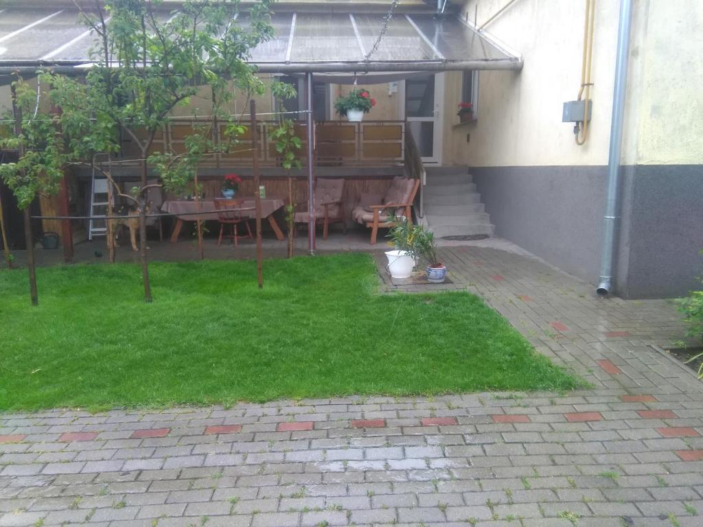 een patio met een tafel en stoelen in een tuin bij Muskatliapartman.cs2. in Paks