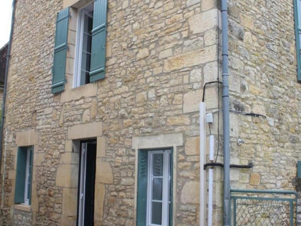 un edificio de piedra con una puerta y ventanas. en Gîte Daglan, 3 pièces, 4 personnes - FR-1-616-93, en Daglan