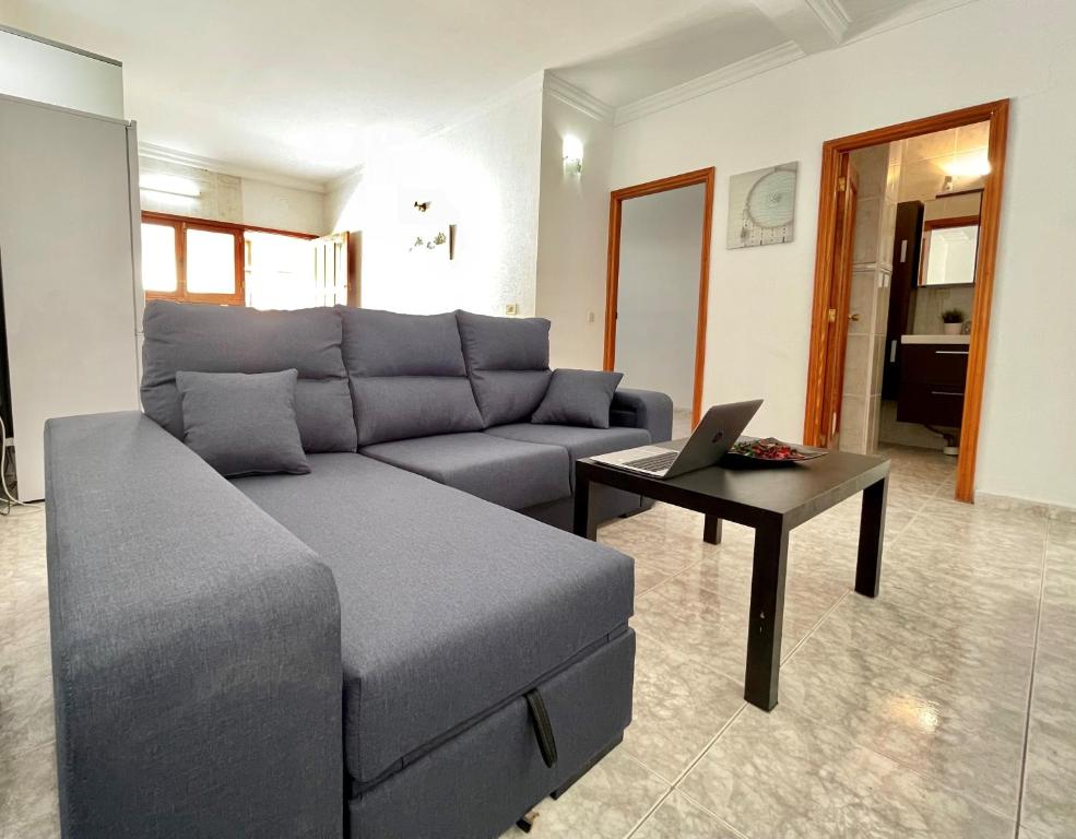 salon z kanapą i laptopem na stole w obiekcie A91 Nice Flat w mieście San Bartolomé