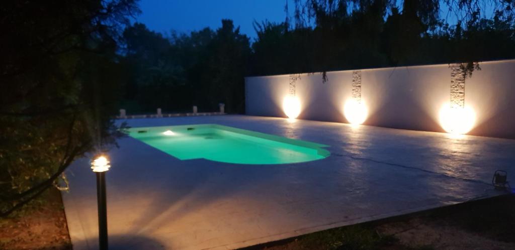 a swimming pool at night with lights at Mas Tareau la Syrah in Beaucaire