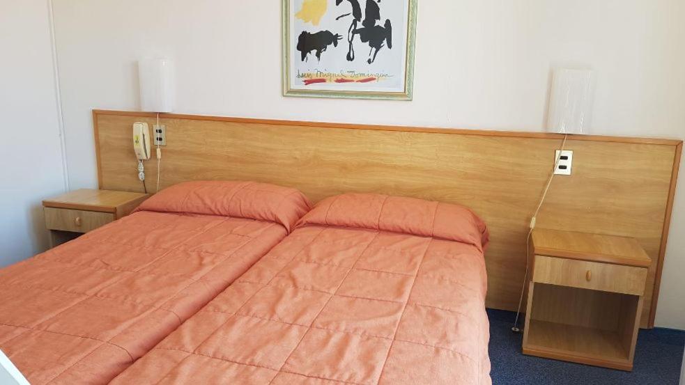1 cama con edredón de naranja en un dormitorio en Malcesine rooms en Malcesine