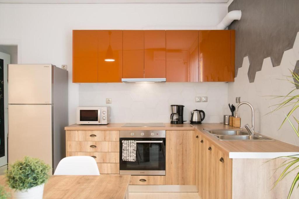 a kitchen with orange cabinets and a sink and a refrigerator at Cozy Apartment in Central Athens - Sleeps 5 in Athens