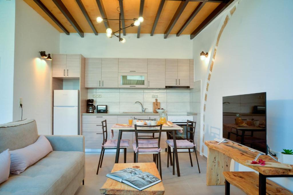 cocina y sala de estar con mesa y sofá en VAMA APARTMENT, en Plataniás