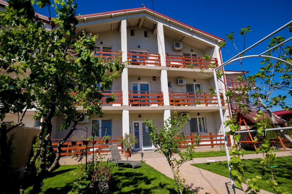 a building with balconies and tables and chairs at Casa Ypu in 2 Mai