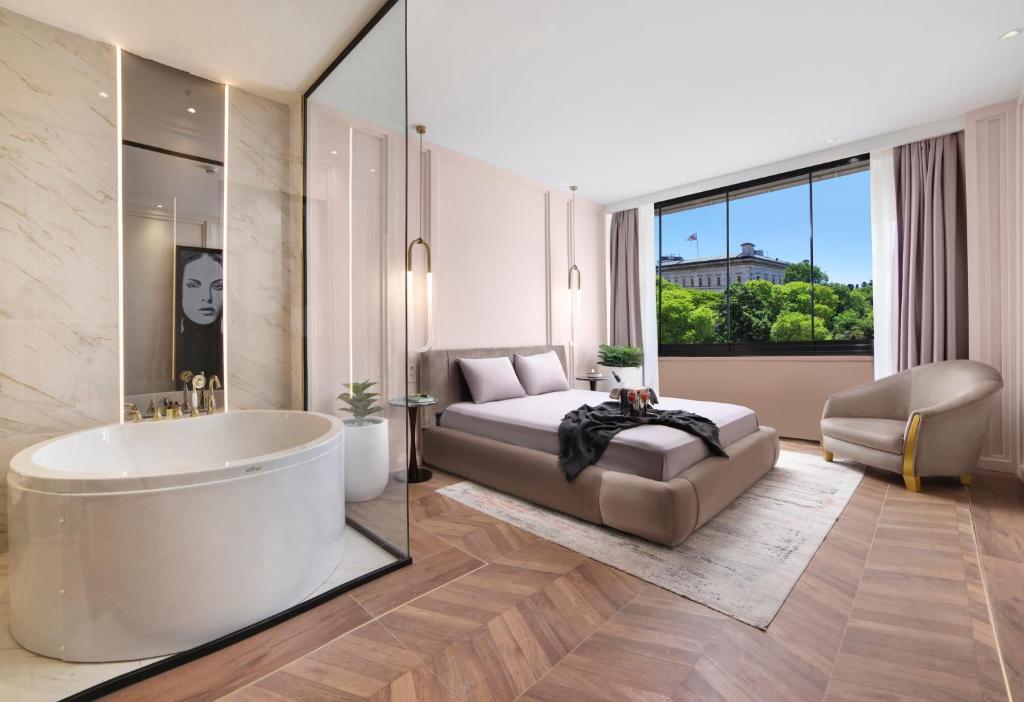 a bedroom with a tub and a bed and a window at Walton Gardens Pera in Istanbul