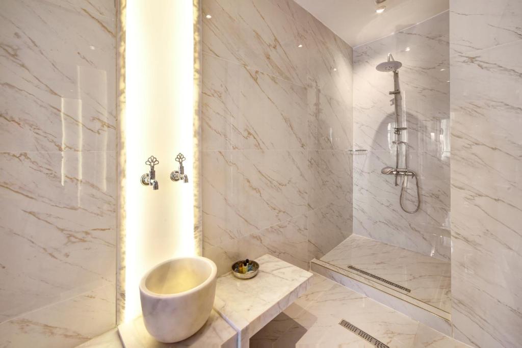 a bathroom with a tub and a shower with a sink at Walton Gardens Pera in Istanbul