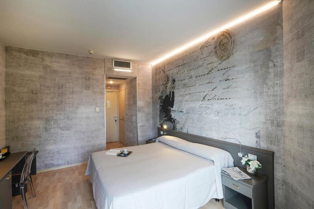 a bedroom with a white bed and a brick wall at Sole Mare in Ventimiglia