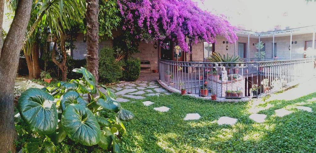 um jardim com cerca e flores roxas em Hotel Pace em Pompeia