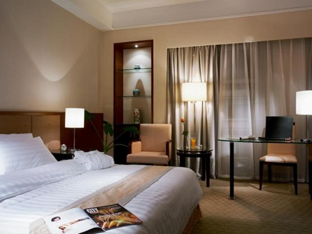 南京市にある金陵晶元プラザのベッドとデスクが備わるホテルルームです。