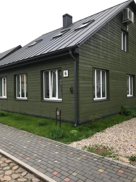 Ein grünes Haus mit der Nummer sechs drauf. in der Unterkunft Daukanto apartamentai in Anykščiai