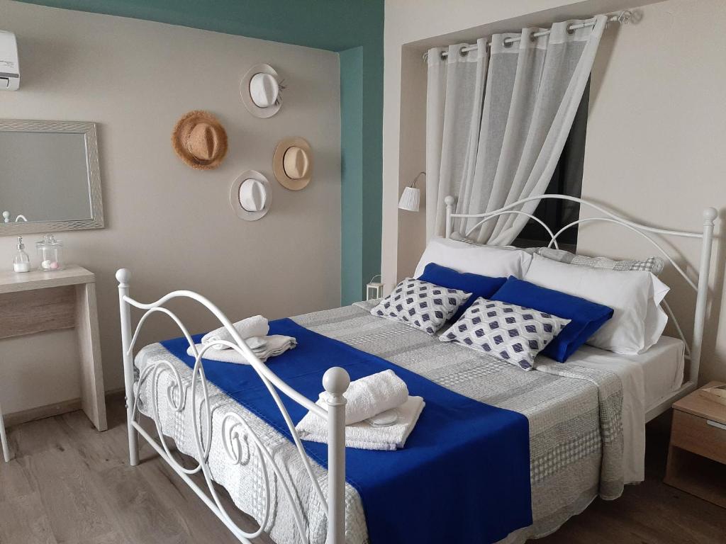 a bedroom with a blue and white bed with pillows at Melissa Keros in Roussopoúlion