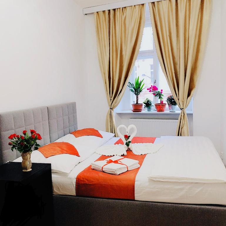 a bed with orange and white pillows and a window at Lena Apartment in Prague