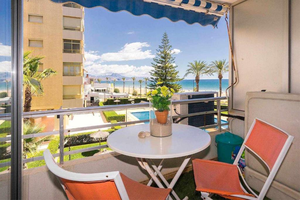 una mesa y sillas en un balcón con vistas al océano en Estudio Voramar Playa San Juan, en El Campello