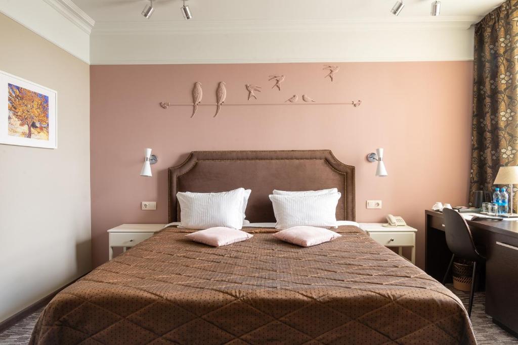 a bedroom with a bed with two pillows on it at Business Hotel Diplomat in Nizhny Novgorod