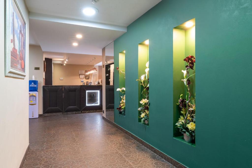 a hallway with green walls with flowers on it at Business Hotel Diplomat in Nizhny Novgorod