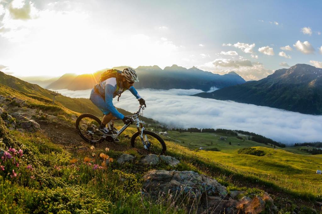 a man riding a bike down a hill on a mountain at Crystal Hotel superior in St. Moritz