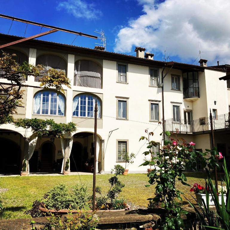 a large white building with windows and a yard at B&B Corte Seguini in Bagnatica
