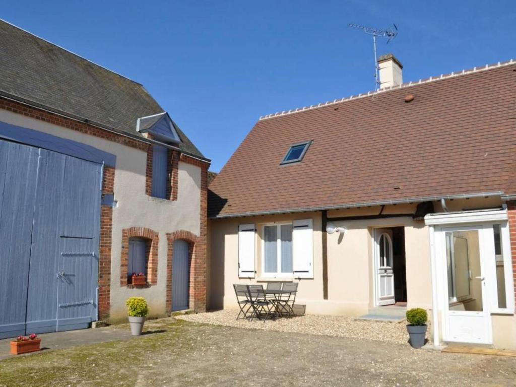 a house with a garage and a building with a blue door at Charmant gîte solognot avec cour privative, proche commerces et nature - FR-1-590-16 in Coullons
