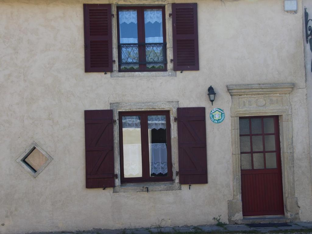 ein Gebäude mit braunen Fensterläden und einer roten Tür in der Unterkunft Gîte Halles-sous-les-Côtes, 4 pièces, 6 personnes - FR-1-585-5 
