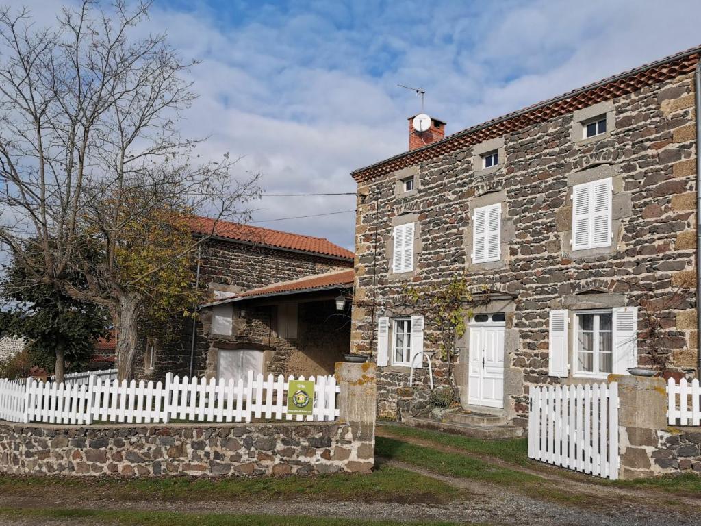 an old stone house with a white picket fence at Gîte Mazeyrat-d'Allier, 4 pièces, 5 personnes - FR-1-582-200 in Mazeyrat-d'Allier