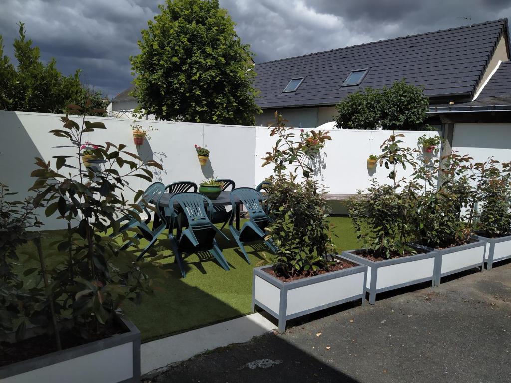 un jardin avec une table, des chaises et des plantes dans l'établissement Appartement Châteauroux, 3 pièces, 4 personnes - FR-1-591-191, à Châteauroux