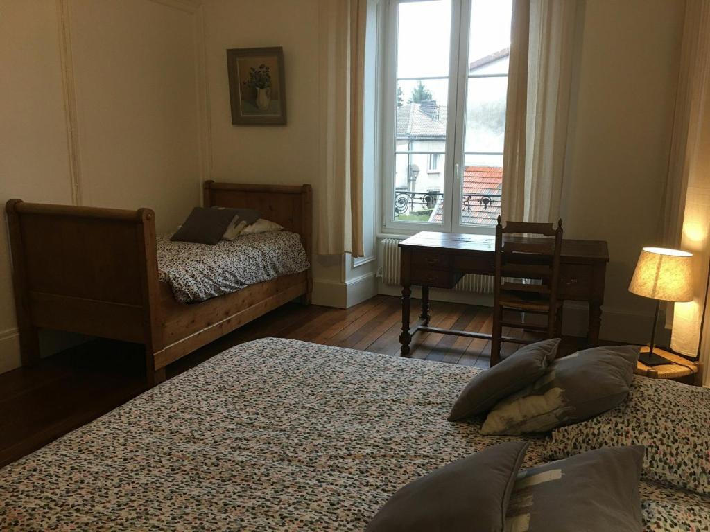 a bedroom with two beds and a desk and a window at Gîte Toul, 5 pièces, 9 personnes - FR-1-584-114 in Toul