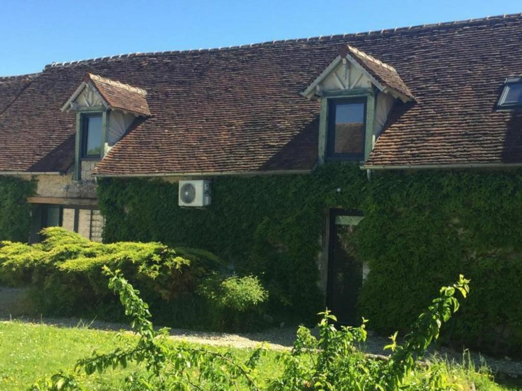 una casa cubierta de hiedra con una ventana y un techo en Gîte Beaune-la-Rolande, 3 pièces, 4 personnes - FR-1-590-114, en Beaune-la-Rolande